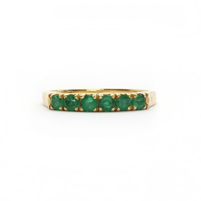 Lot 97 - A gold and emerald half eternity ring