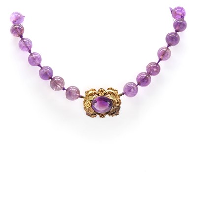 Lot 1 - A graduated circular amethyst bead necklace with an amethyst brooch centrepiece