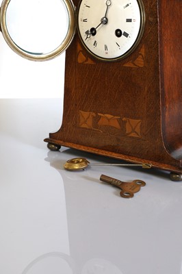 Lot 115 - An Art Nouveau oak mantel clock