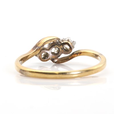 Lot 41 - A gold crossover design three stone diamond ring