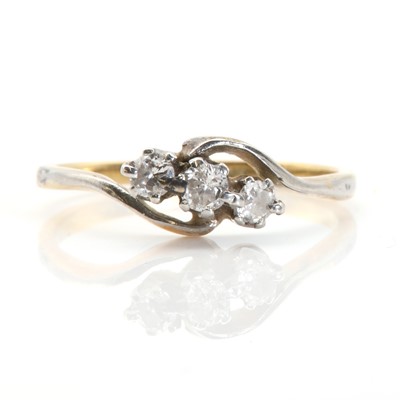 Lot 41 - A gold crossover design three stone diamond ring
