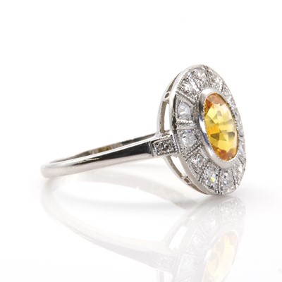 Lot 64 - A yellow sapphire and diamond oval cluster ring