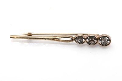 Lot 74 - A three stone diamond tapered bar brooch