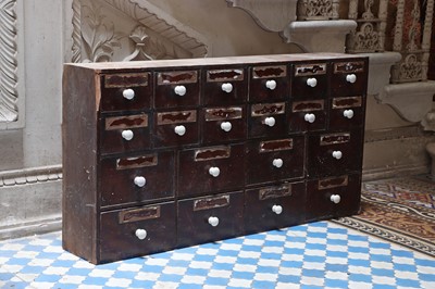 Lot 421 - ☘ A pharmacist's bank of stained pine medicine drawers