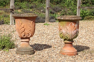 Lot 525 - A pair of terracotta coloured reconstituted stone garden urns