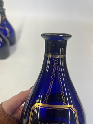 Lot 325 - A near set of five Regency Bristol blue glass decanters