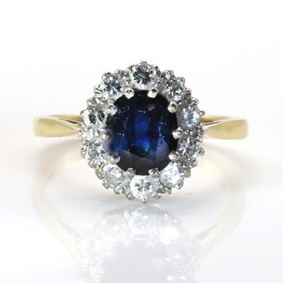 Lot 157 - An 18ct yellow and white gold, sapphire and diamond oval cluster ring