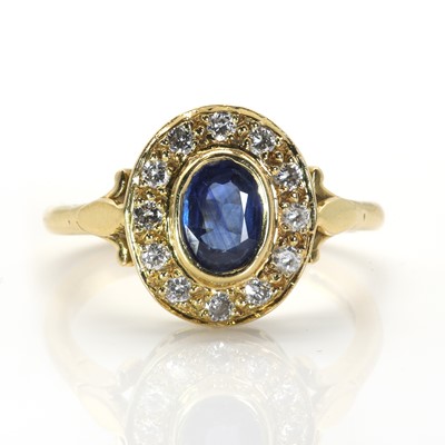 Lot 153 - An 18ct gold sapphire and diamond oval cluster ring