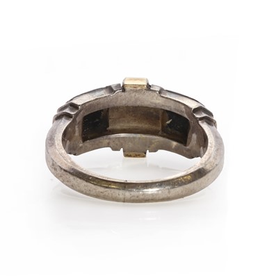 Lot 102 - A sterling silver gold and onyx ring, by Cartier