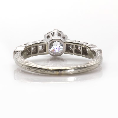 Lot 100 - A single stone diamond ring with diamond set shoulders