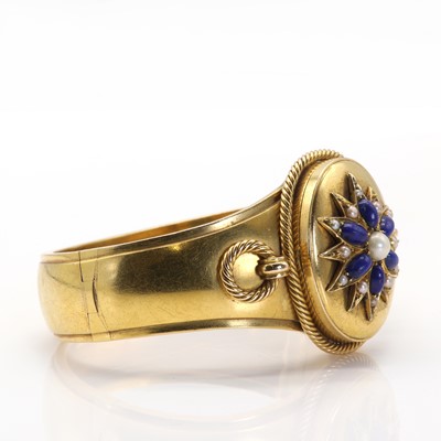 Lot 11 - A Victorian gold, lapis lazuli and pearl hinged bangle with double-sided locket