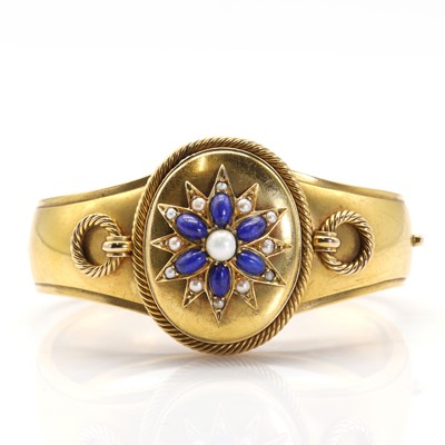 Lot 11 - A Victorian gold, lapis lazuli and pearl hinged bangle with double-sided locket