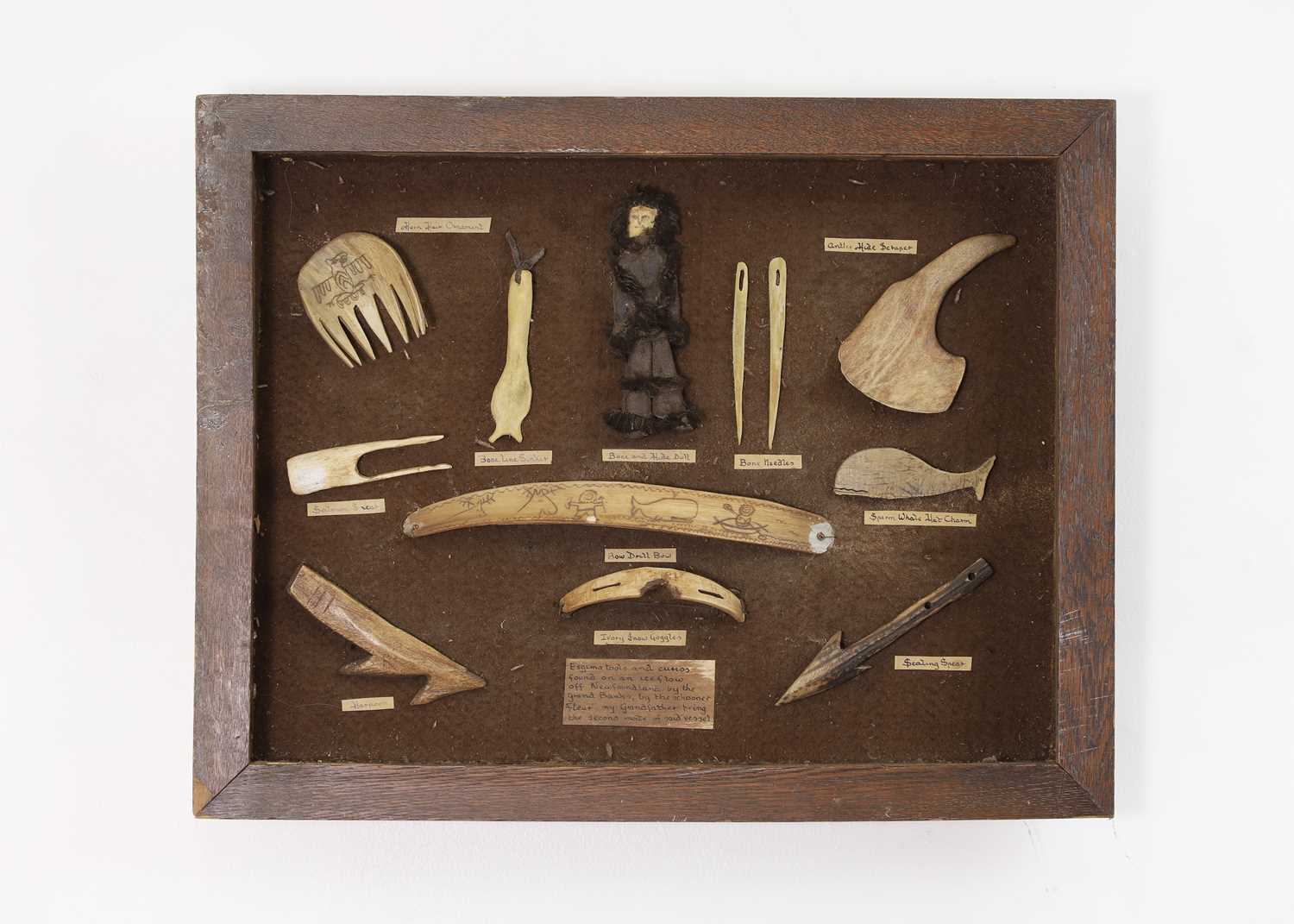 Lot 448 - An oak-framed display of marine ivory, bone and antler 'tools and curios'