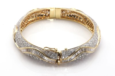 Lot 77 - A vari-cut diamond hinged bangle