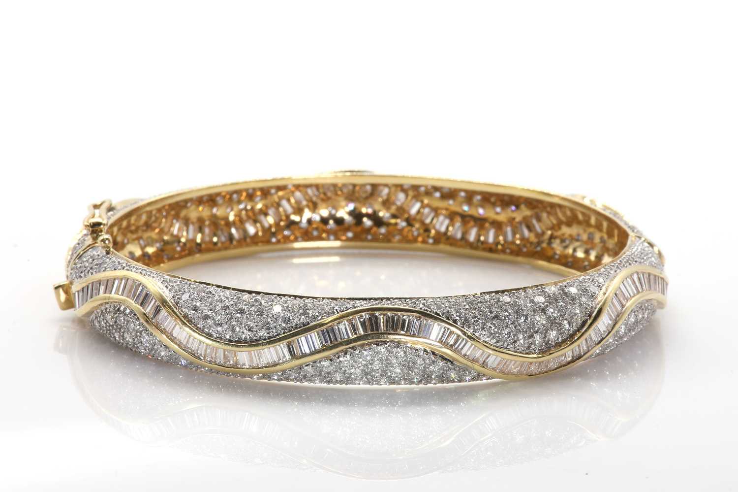 Lot 77 - A vari-cut diamond hinged bangle
