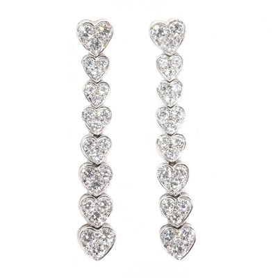 Lot 1055 - A pair of white gold articulated heart diamond drop earrings
