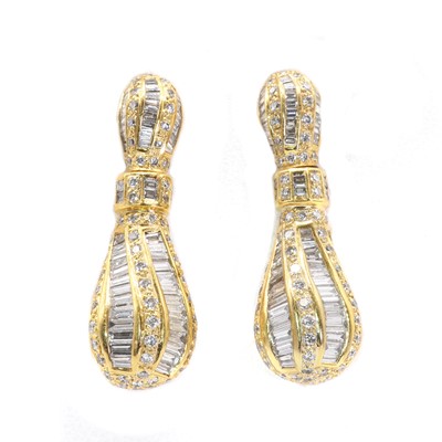 Lot 75 - A pair of baguette and round cut diamond pendant earrings