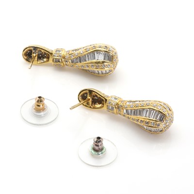 Lot 75 - A pair of baguette and round cut diamond pendant earrings