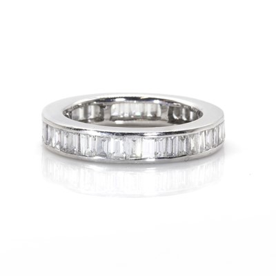 Lot 101 - A baguette cut diamond full eternity ring