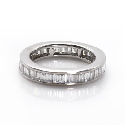 Lot 101 - A baguette cut diamond full eternity ring