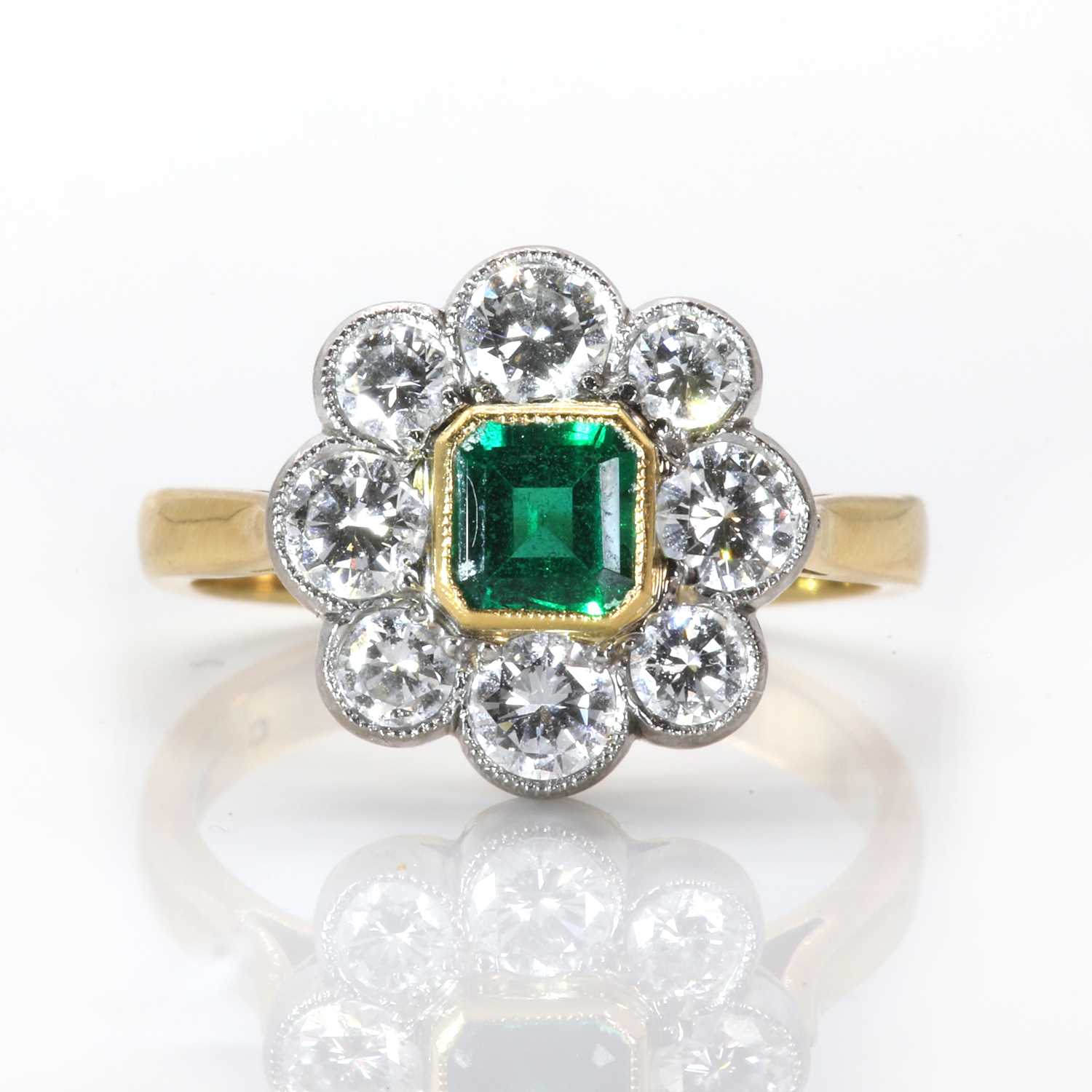 Lot 109 - An 18ct gold emerald and diamond daisy cluster ring