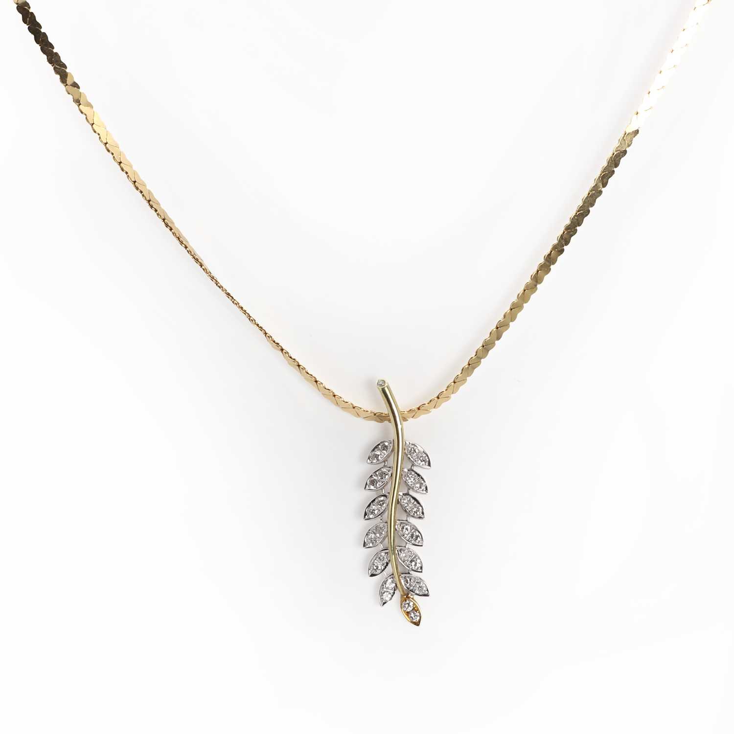 Lot 1052 - A two colour gold diamond leaf design pendant and chain