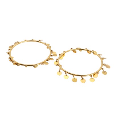 Lot 1233 - A set of two 18ct gold bangles with disc-shaped charms