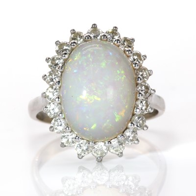 Lot 119 - A white gold opal and diamond oval cluster ring