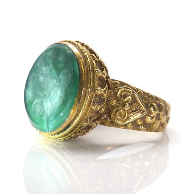 Lot 262 - A chrysoprase intaglio ring in ornate mount