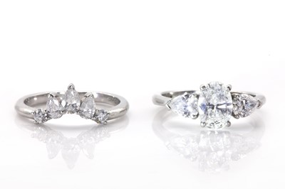 Lot 135 - A platinum and diamond three stone ring and a fitted diamond set ring guard