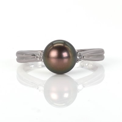 Lot 115 - A black cultured pearl ring with two diamond highlights