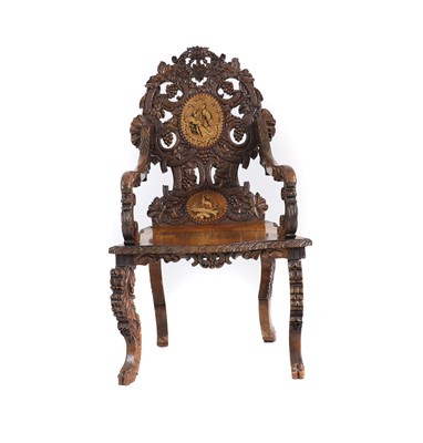 Lot 369 - A carved Black Forest elbow chair