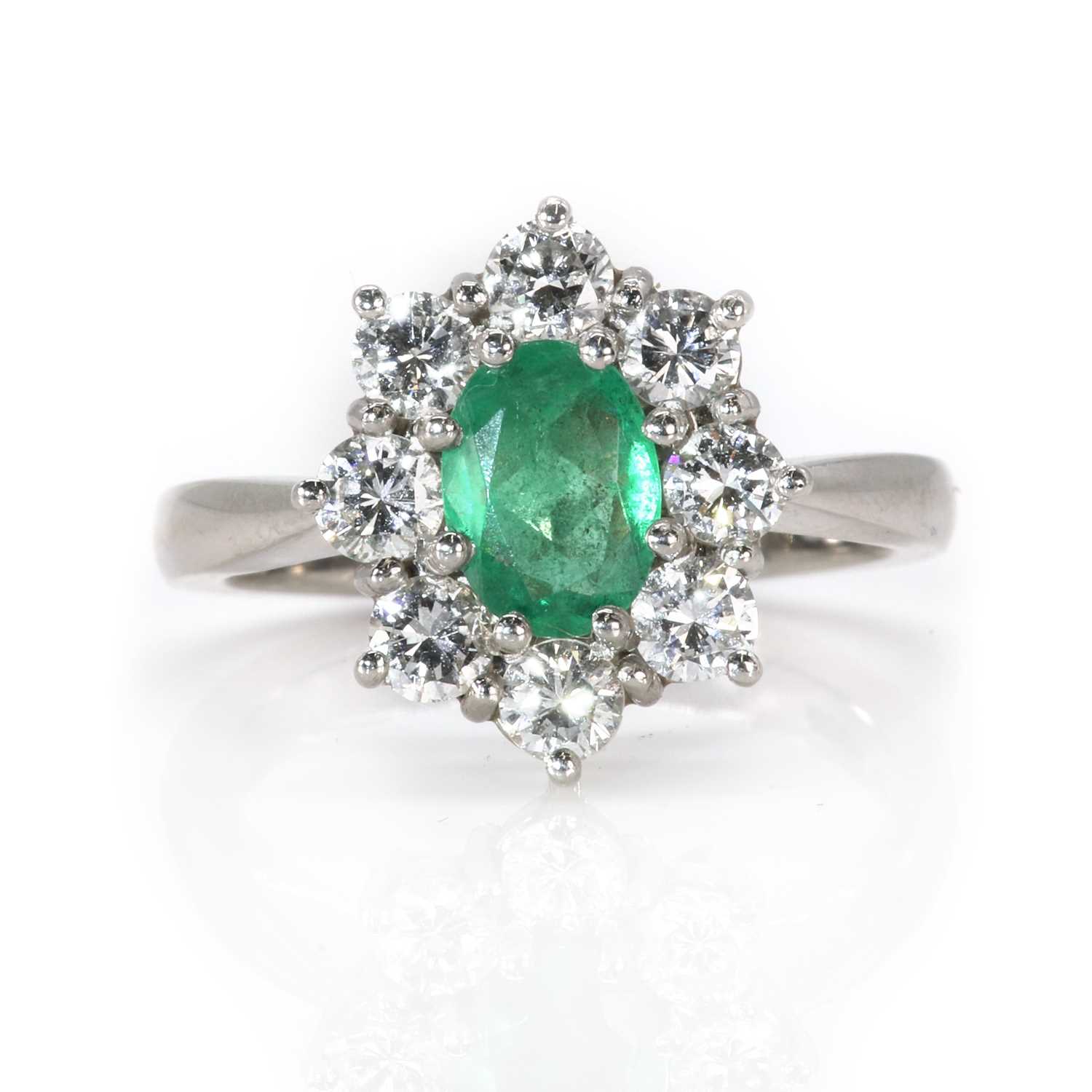 Lot 87 - A platinum emerald and diamond cluster ring