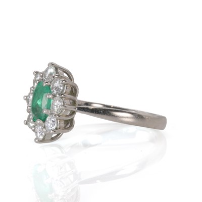 Lot 87 - A platinum emerald and diamond cluster ring