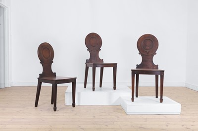 Lot 420 - A set of three George III mahogany hall chairs