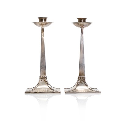Lot 12 - A pair of Arts and Crafts silver candlesticks