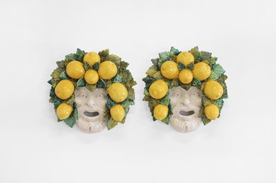 Lot 146 - A pair of glazed pottery wall-hanging masks