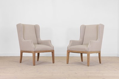 Lot 371 - A pair of oak wingback armchairs by OKA