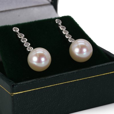 Lot 152 - A pair of white gold diamond and cultured pearl drop stud earrings