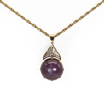 Lot 87 - A large purplish red star ruby pendant and chain