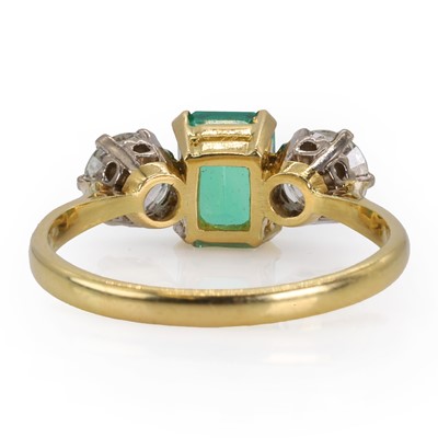 Lot 180 - An 18ct gold Colombian emerald and diamond three stone ring