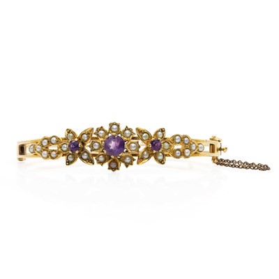 Lot 125 - A 9ct gold amethyst and seed pearl floral bangle
