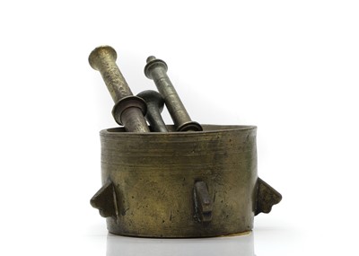 Lot 164 - An Islamic brass mortar and three pestles
