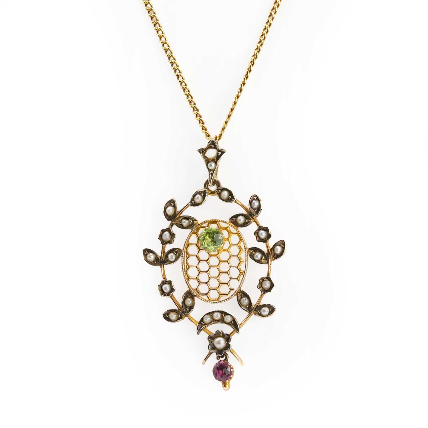 Lot 52 - A Belle Époque peridot, ruby and split pearl openwork pendant