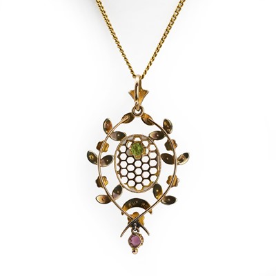 Lot 52 - A Belle Époque peridot, ruby and split pearl openwork pendant