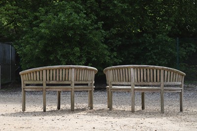 Lot 98 - A pair of curved teak garden benches