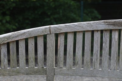 Lot 98 - A pair of curved teak garden benches