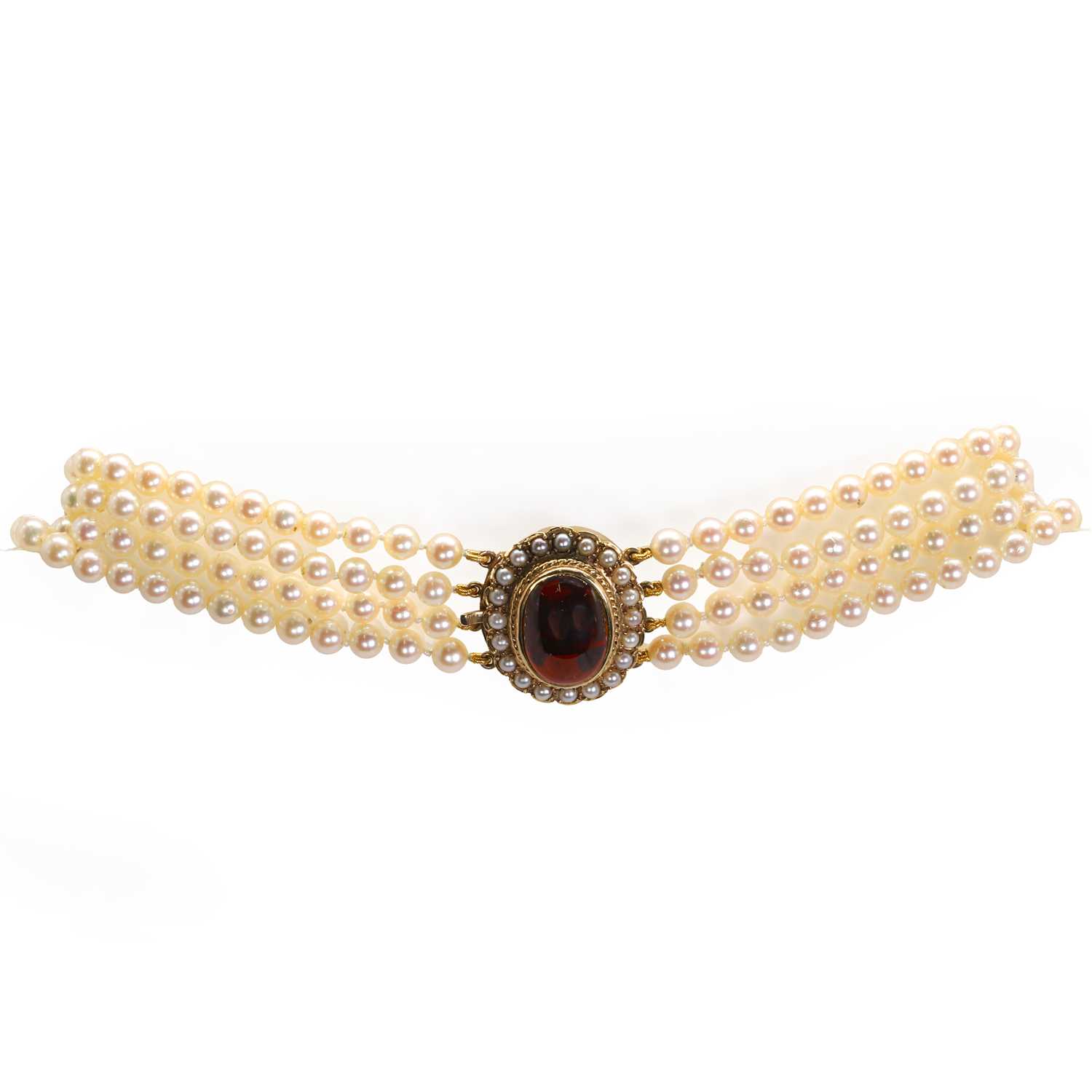 Lot 215 - A uniform four row cultured pearl necklace with a garnet set clasp