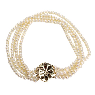 Lot 215 - A uniform four row cultured pearl necklace with a garnet set clasp