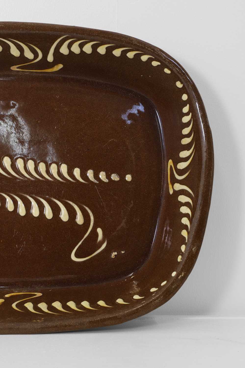 Lot 401 - A large glazed earthenware slipware dish